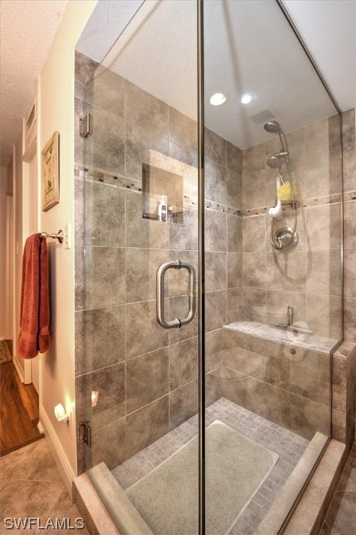 bathroom with a shower with door and tile floors