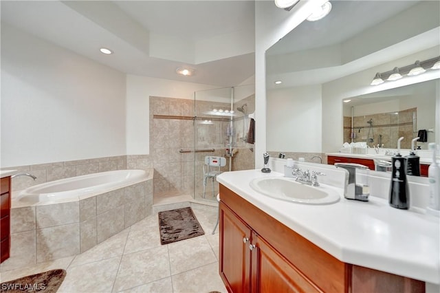 bathroom featuring tile patterned flooring, vanity, and shower with separate bathtub