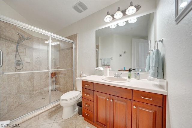 bathroom featuring vanity, tile patterned floors, toilet, and walk in shower