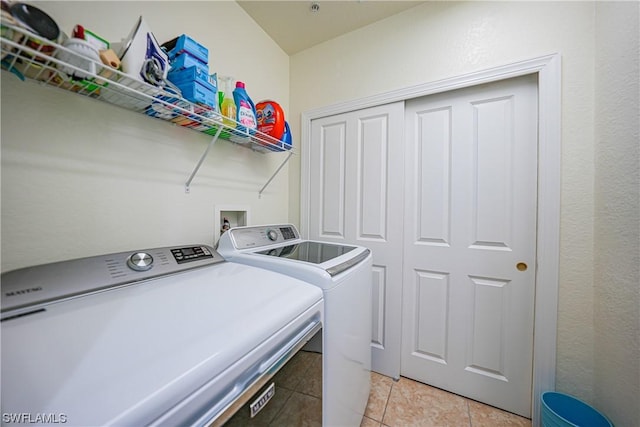 laundry area with light tile patterned flooring and washer and dryer