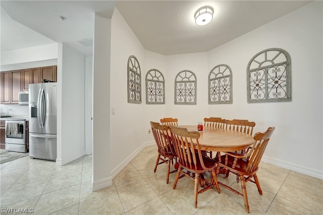 dining area with light tile patterned floors and a textured ceiling