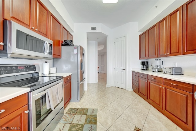 kitchen with stainless steel appliances and light tile patterned flooring