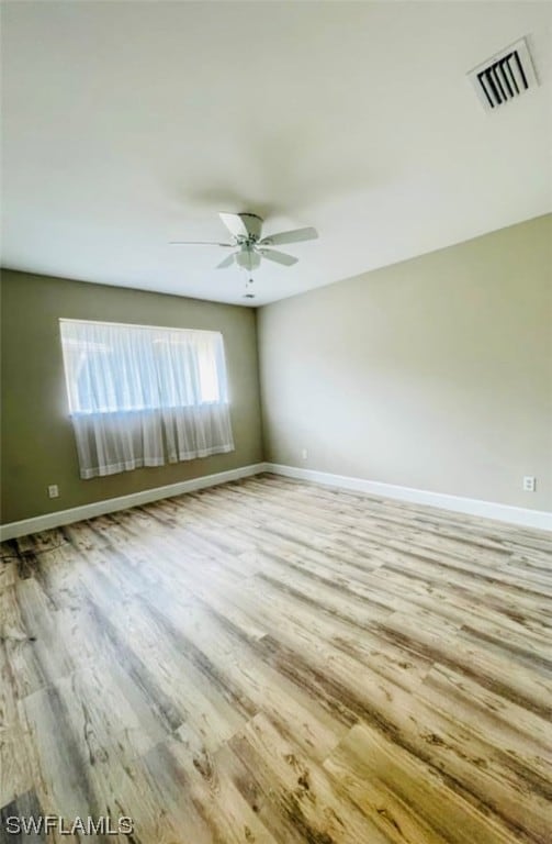 spare room with ceiling fan and light wood-type flooring