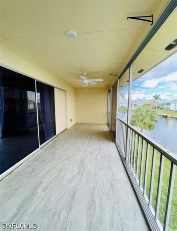 balcony with a water view and ceiling fan