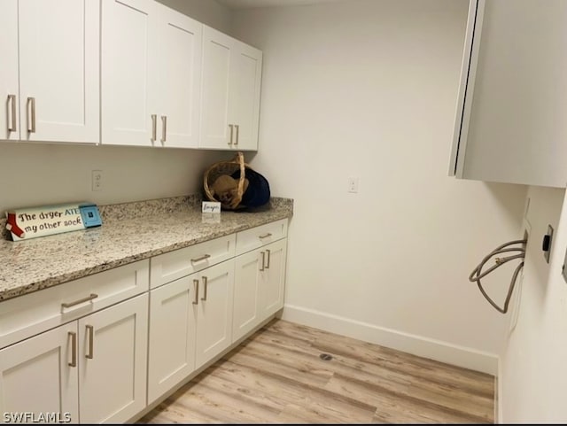 washroom featuring cabinets and light hardwood / wood-style flooring