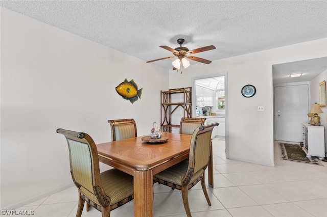 dining room featuring light tile floors, ceiling fan, and a textured ceiling