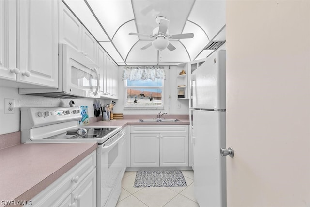 kitchen with white appliances, ceiling fan, light tile floors, sink, and white cabinets