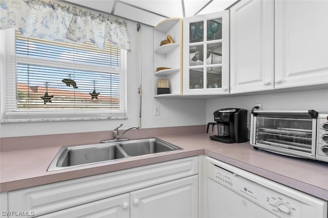 kitchen featuring white cabinets, dishwasher, and sink