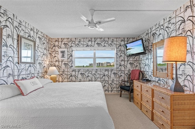 carpeted bedroom with a textured ceiling, ceiling fan, and multiple windows