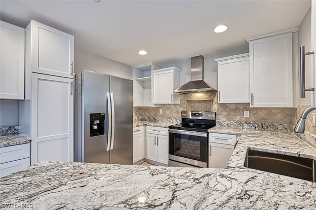 kitchen with sink, appliances with stainless steel finishes, backsplash, wall chimney range hood, and white cabinetry