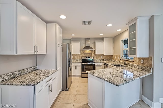 kitchen with light stone countertops, sink, stainless steel appliances, light tile floors, and wall chimney exhaust hood