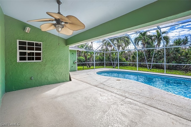 view of swimming pool with a patio, a lanai, and ceiling fan