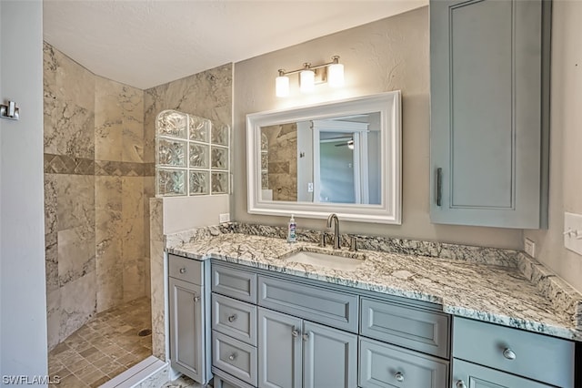 bathroom with vanity and a tile shower