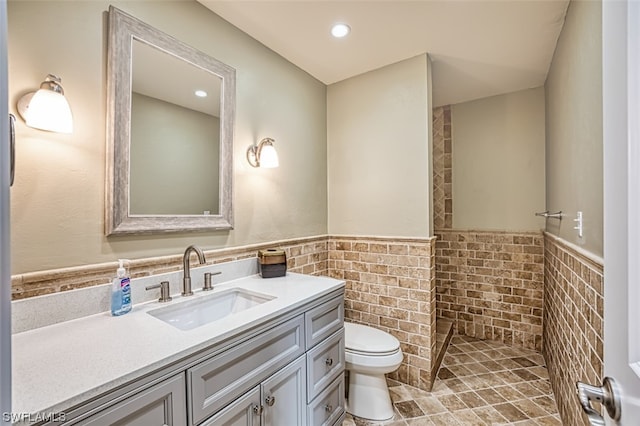 bathroom featuring toilet, vanity, tile walls, backsplash, and tile floors