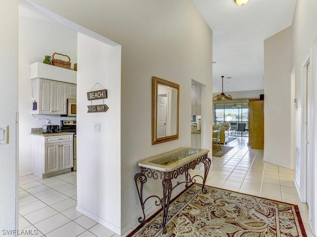 hallway with light tile patterned floors and baseboards