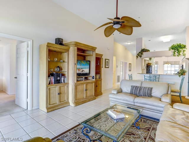 living area with light tile patterned flooring, high vaulted ceiling, and ceiling fan