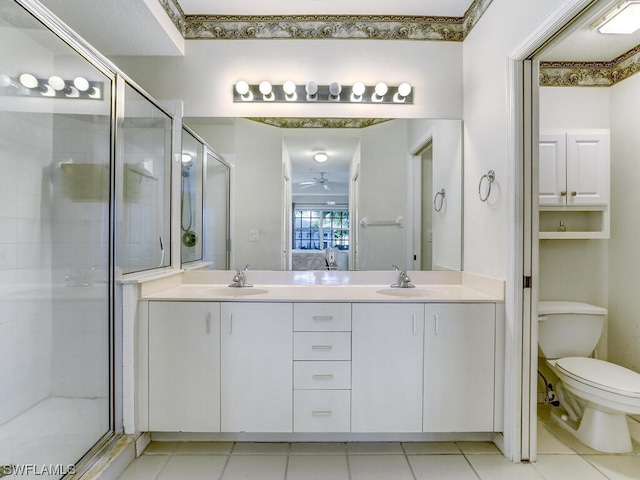 ensuite bathroom with double vanity, a shower stall, toilet, and a sink