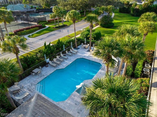 community pool with a patio and fence