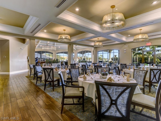 dining space featuring visible vents, an inviting chandelier, wood finished floors, and crown molding