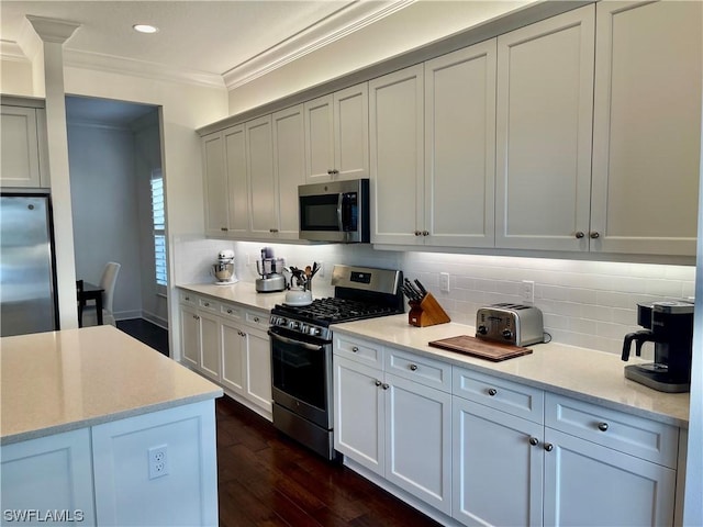 kitchen with light stone countertops, ornamental molding, tasteful backsplash, dark hardwood / wood-style flooring, and stainless steel appliances