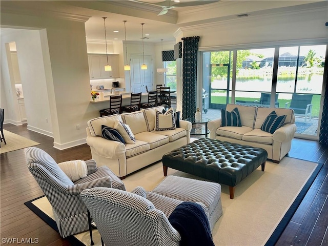 living room with a wealth of natural light, ornamental molding, and hardwood / wood-style flooring