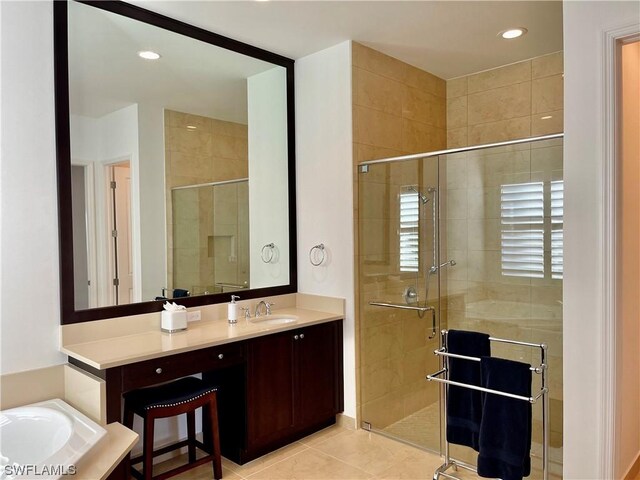 bathroom featuring plus walk in shower, vanity, and tile patterned floors