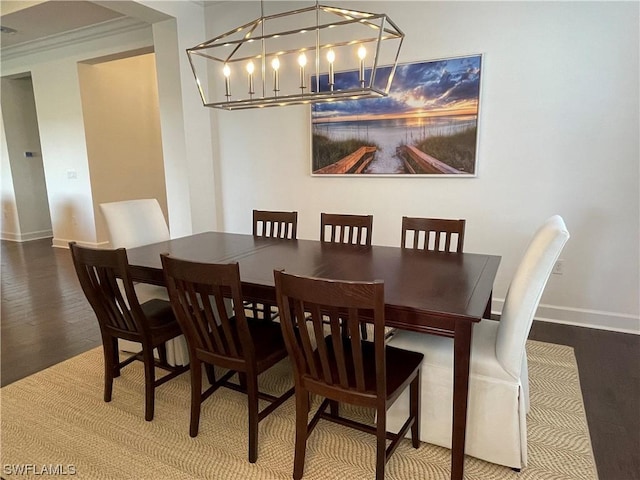 dining area with hardwood / wood-style floors and an inviting chandelier