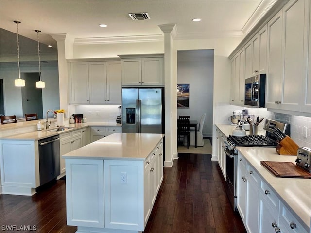 kitchen with pendant lighting, sink, stainless steel appliances, and dark hardwood / wood-style floors