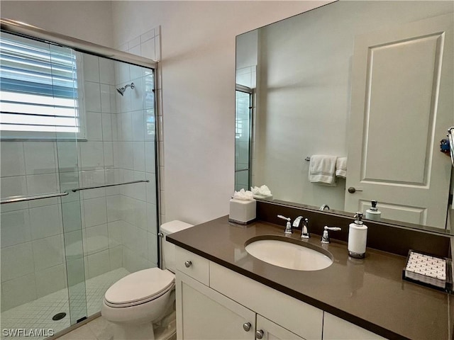 bathroom featuring vanity, toilet, and an enclosed shower