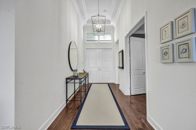 entryway featuring dark hardwood / wood-style flooring, a notable chandelier, and ornamental molding