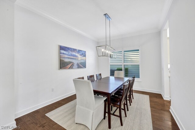 dining space featuring a notable chandelier, crown molding, and dark wood-type flooring