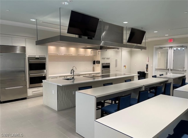 kitchen featuring sink, an island with sink, pendant lighting, and appliances with stainless steel finishes