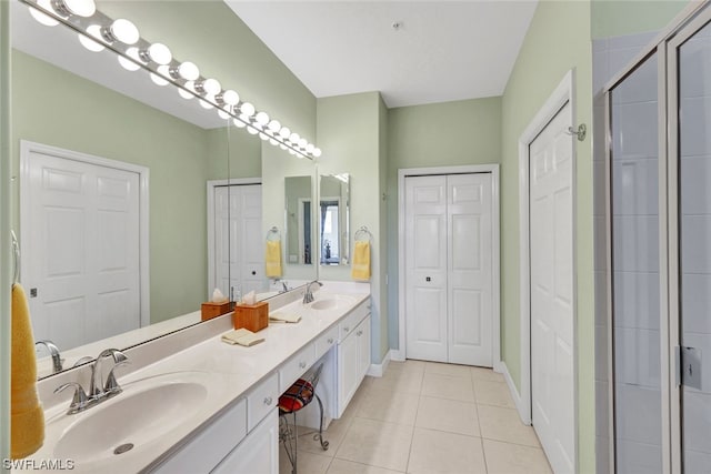 bathroom featuring an enclosed shower, oversized vanity, tile flooring, and dual sinks