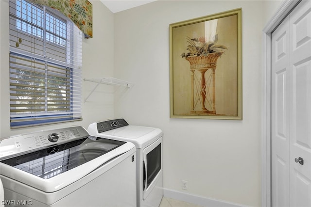 washroom featuring separate washer and dryer and light tile floors