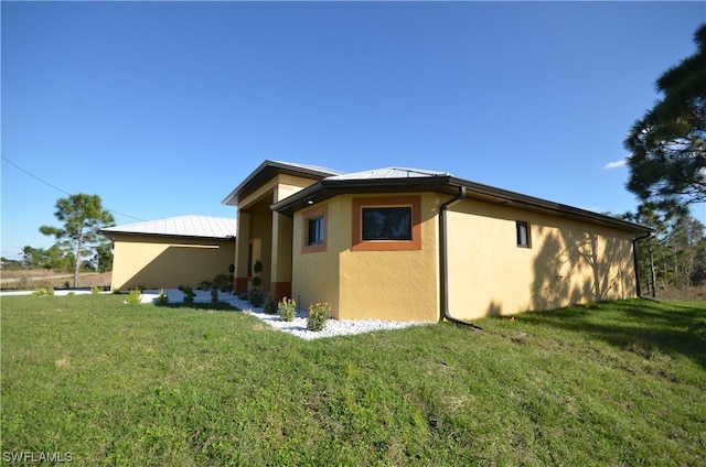 view of side of property with a lawn