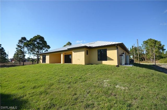 rear view of property with a lawn