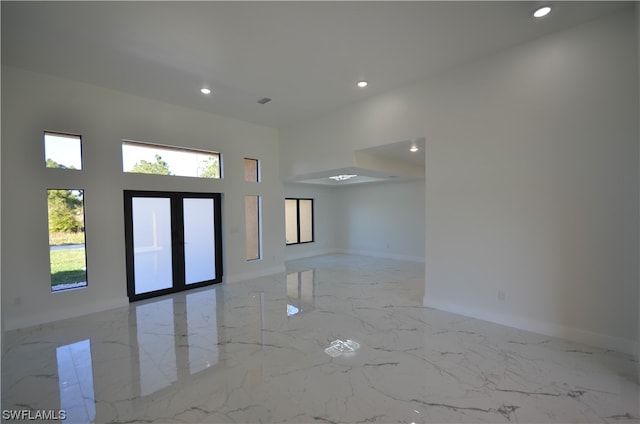 unfurnished room featuring light tile floors and a healthy amount of sunlight