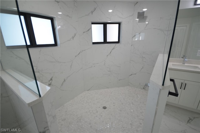 bathroom with vanity, plenty of natural light, tile flooring, and tiled shower