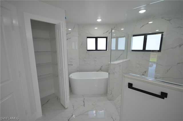 bathroom with tile walls, a washtub, and tile floors