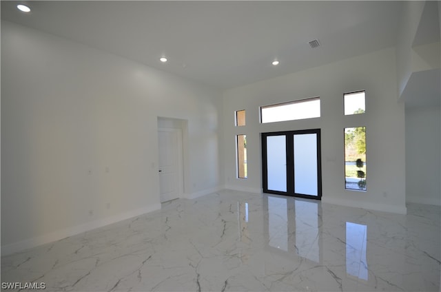 entrance foyer with light tile flooring and a high ceiling