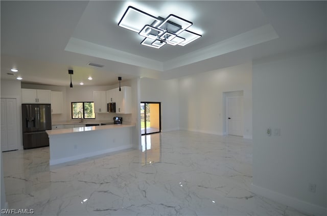 kitchen with white cabinets, black fridge with ice dispenser, a tray ceiling, and light tile floors