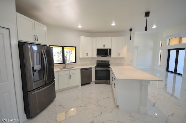 kitchen with appliances with stainless steel finishes, hanging light fixtures, sink, and white cabinetry