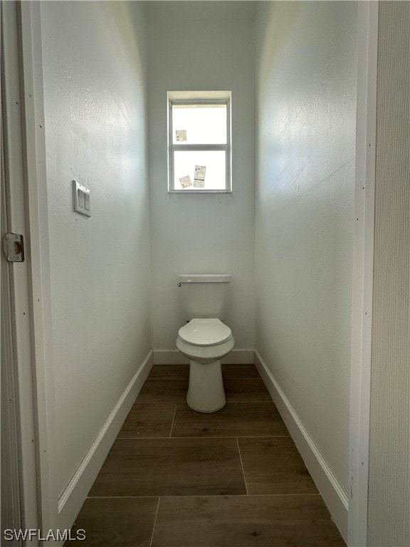 bathroom with toilet and hardwood / wood-style flooring