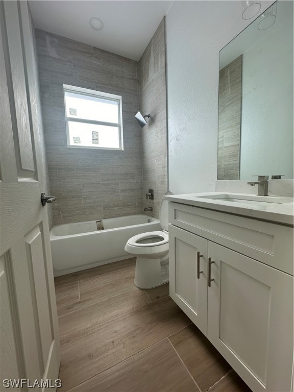 full bathroom with vanity, tile flooring, toilet, and tiled shower / bath