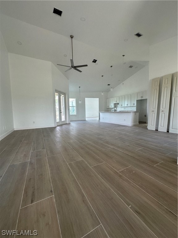 unfurnished living room featuring high vaulted ceiling, ceiling fan, dark wood-type flooring, and sink