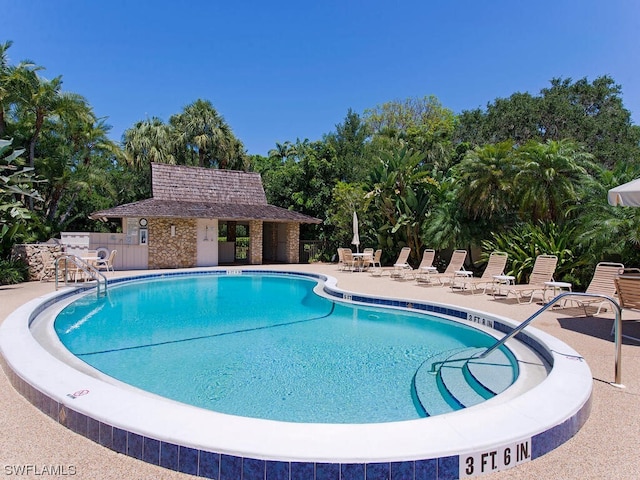 view of pool with a patio area and an outdoor structure