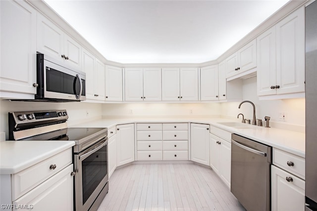 kitchen with stainless steel appliances, white cabinets, and sink