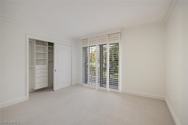 unfurnished bedroom featuring a closet, crown molding, and carpet floors