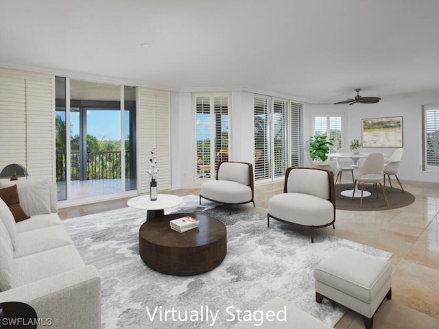 living room featuring ceiling fan and a wall of windows