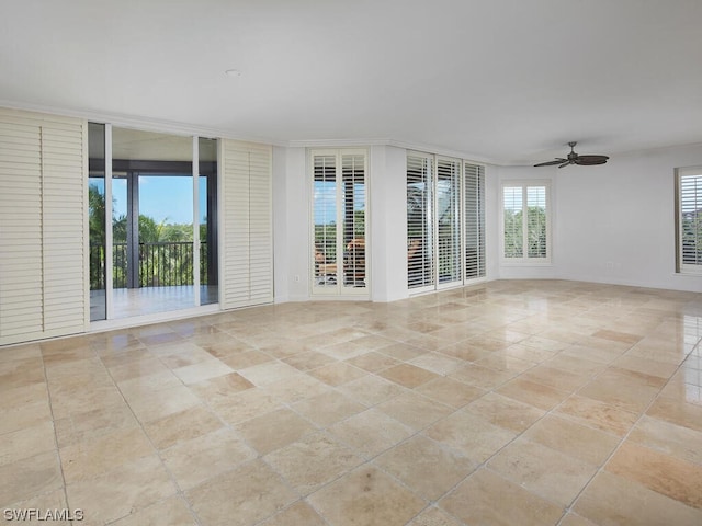 tiled spare room featuring ornamental molding and ceiling fan